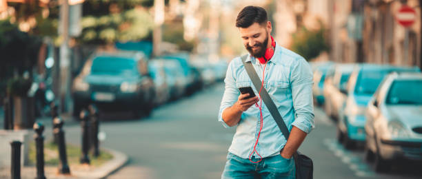 istock Smiling man texting on the street 1086383004