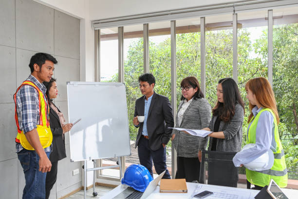 istock Engineers are meeting on the whiteboard. Blueprint Interior Design structure and development. contractor presentation for team and client in the office. Asian people. 1086389736