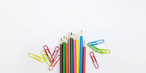 istock Modern office supplies concepts, Colored crayon pencils and clips on white background. 1086395508