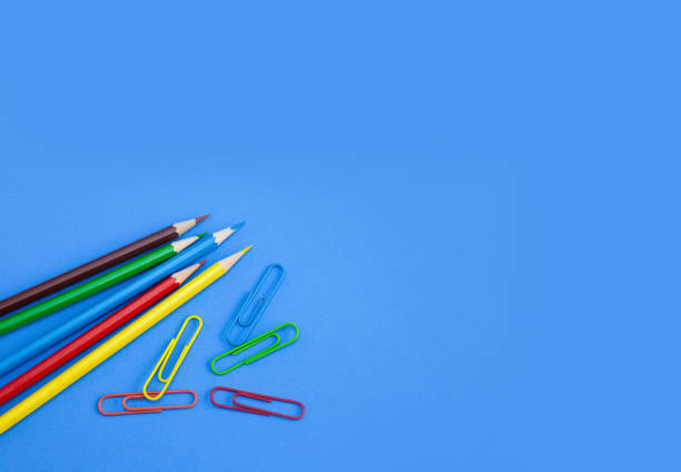 istock School supplies concepts, Multi-colored pencils and clips on blue background. 1086395612