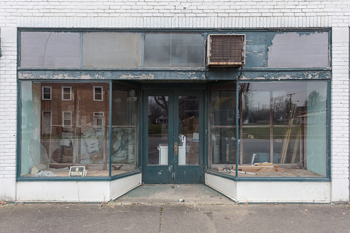 Large window storefront with green and white paint in small town business district