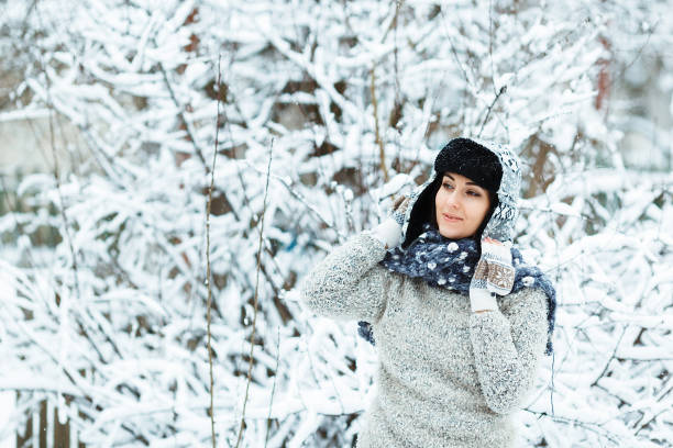 istock Happy woman enjoys falling snow in the yard 1086409962