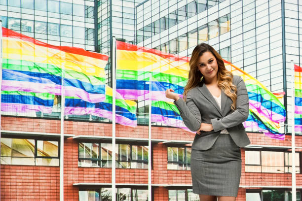 businesswoman in front of gay flag - homosexual gay pride business rainbow imagens e fotografias de stock