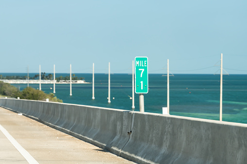Bahia Honda Key, USA Mile 71 marker, mark, green sign at overseas highway road, blocks, ocean, sea on bridge passage in Florida