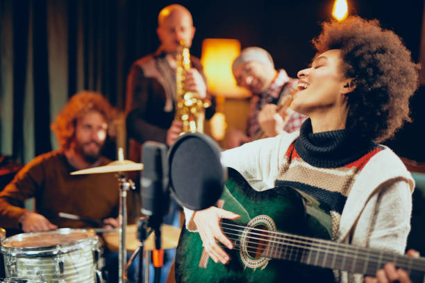 istock Mixed race woman singing and playing guitar 1086430088