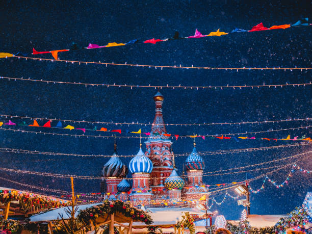 cattedrale di san basilio tra decorazioni festive di capodanno sulla piazza rossa a mosca. fiera di natale in russia di sera mentre cade la neve. - snow cupola dome st basils cathedral foto e immagini stock