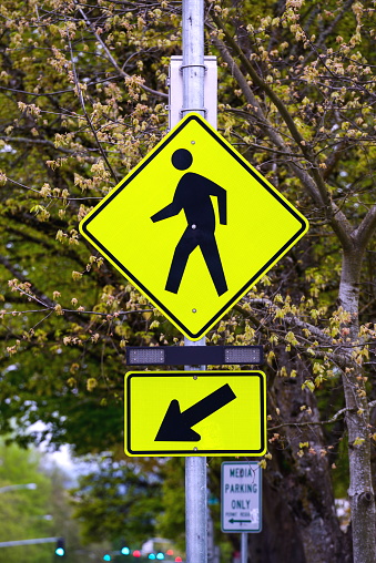 Stock photo showing close-up view of warning sign advising of prohibited  cycling, running, roller blading and skateboarding in public park gardens.