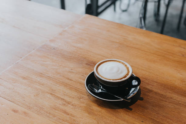 istock hot coffee in black cup on wooden table. 1086483468