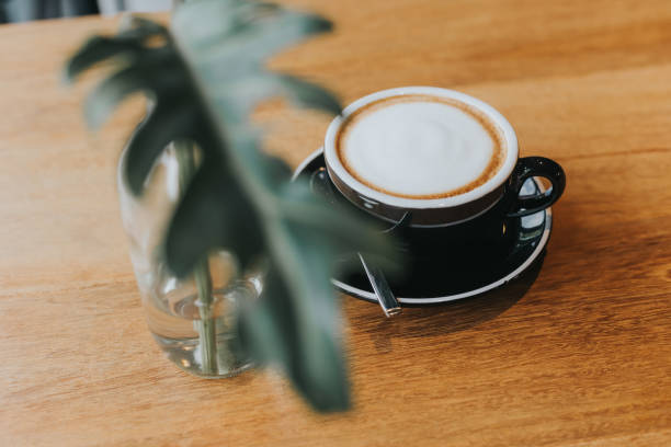 istock hot coffee in black cup on wooden table. 1086483618