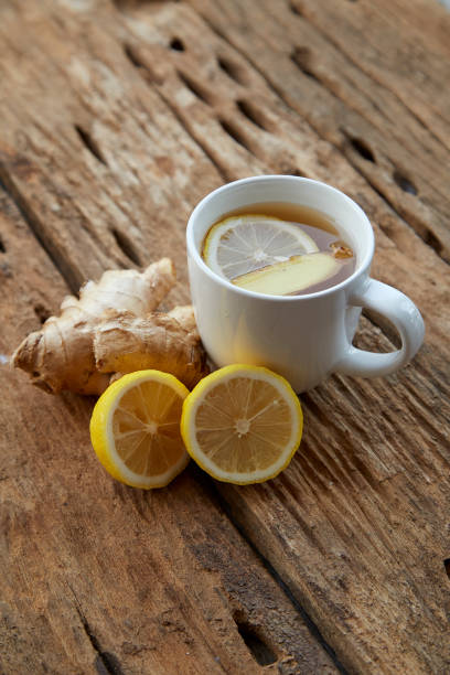 istock Cup of ginger tea with lemon on wooden table 1086486410
