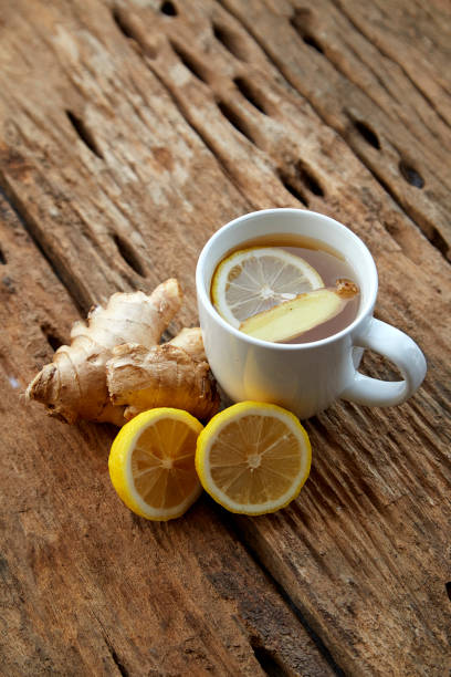 istock Cup of ginger tea with lemon on wooden table 1086486414