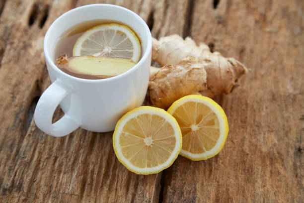 istock Cup of ginger tea with lemon on wooden table 1086486426