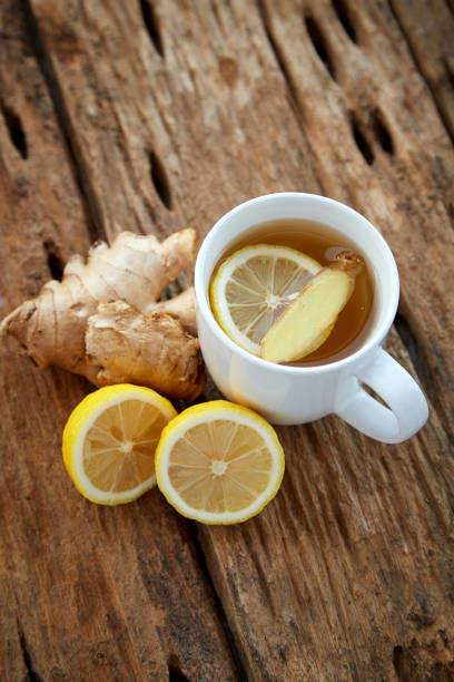 istock Cup of ginger tea with lemon on wooden table 1086486428