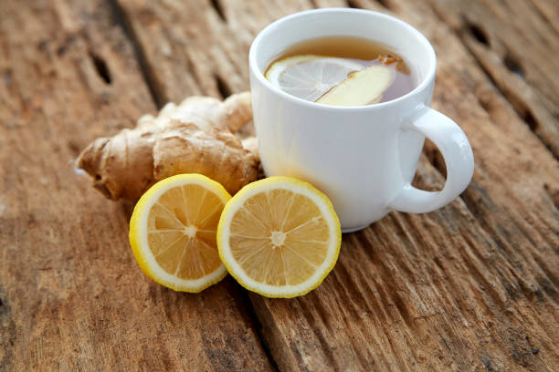 istock Cup of ginger tea with lemon on wooden table 1086486430