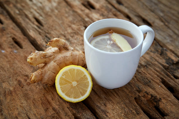 istock Cup of ginger tea with lemon on wooden table 1086486448