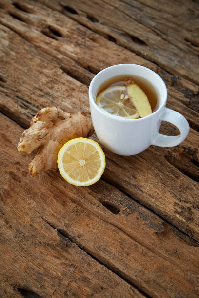 istock Cup of ginger tea with lemon on wooden table 1086486454
