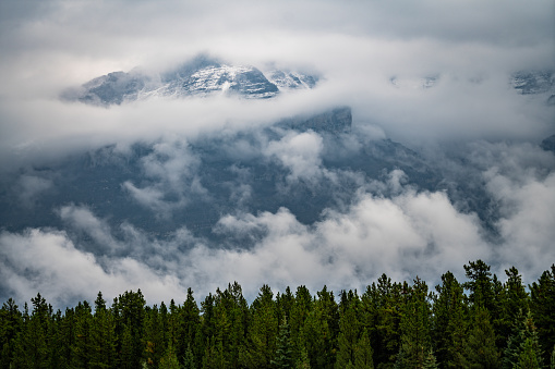This image captures an enormous peak from the valley floor along the Road to Jasper in Alberta, Canada. This stretch of road is known to be one of the most scenic in the world and the breaking clouds after an intense mountain storm only added to the drama. A dusting of snow can be seen in the high peaks, which was the first snow of the season, taking place in August.