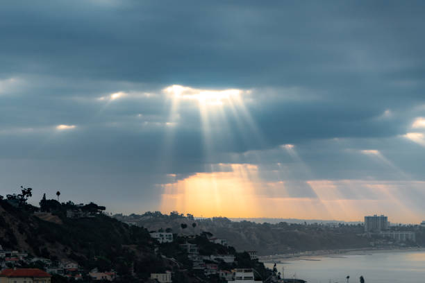 Sunbeams over Santa Monica This image was captured in the morning while looking out over Santa Monica from Malibu. The sunlight beamed through the clouds casting these sun beams. rock sea malibu silhouette stock pictures, royalty-free photos & images