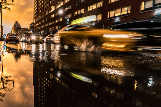 Speeding NYC Taxi A picture of a speeding taxi smashing through a puddle in NYC after a summer thunderstorm.  The afternoon thunderstrorms always provide the best light in the summer. This image was captured in Union Square - on 14th street. union square new york city stock pictures, royalty-free photos & images