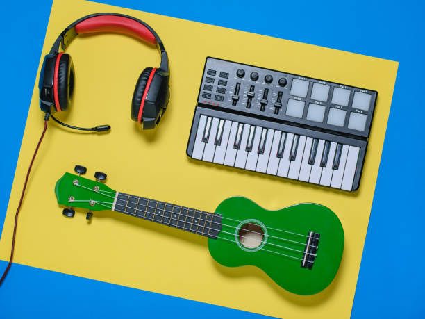 istock Ukulele ukulele ukulele and wired blue microphone on blue and yellow background. The view from the top. 1086490542