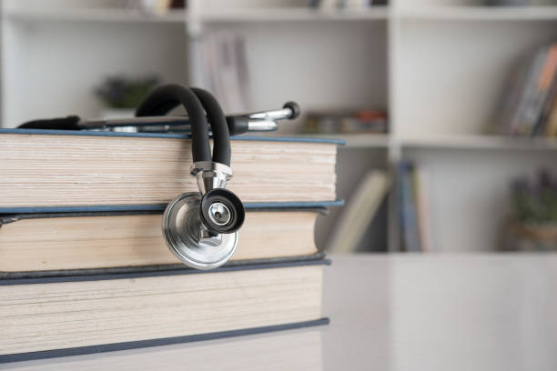 medical education stethoscope on stack of medical text book on doctor desk at room in hospital. medical education stock pictures, royalty-free photos & images