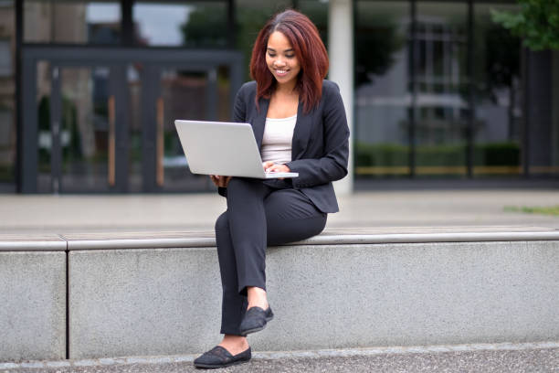istock Young woman sitting in town working on a laptop 1086524568