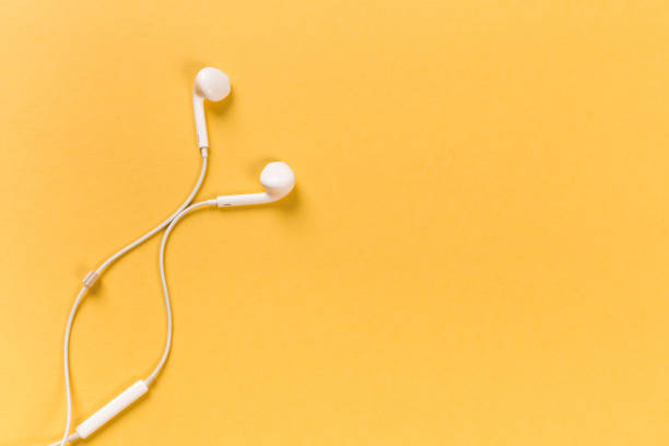 istock White earphones on orange background 1086534148