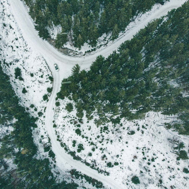 istock overhead view of suv car in snowed winter forest. 1086539254