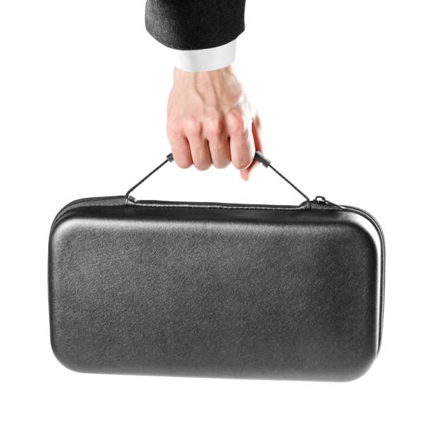 istock A man's hand holds a black plastic suitcase. Close up. Isolated on white background 1086550960