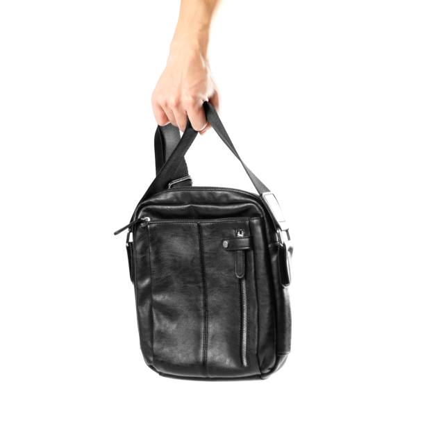 istock Hand holding black leather men's bag. Close up. Isolated on white background 1086550970