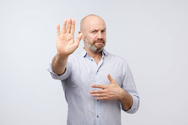 istock European man showing stop sign over gray background 1086558714