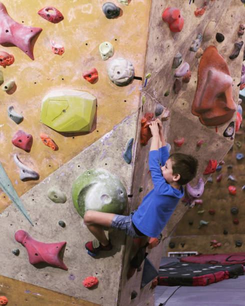 istock Little boy climbing a rock wall indoor. 1086560614