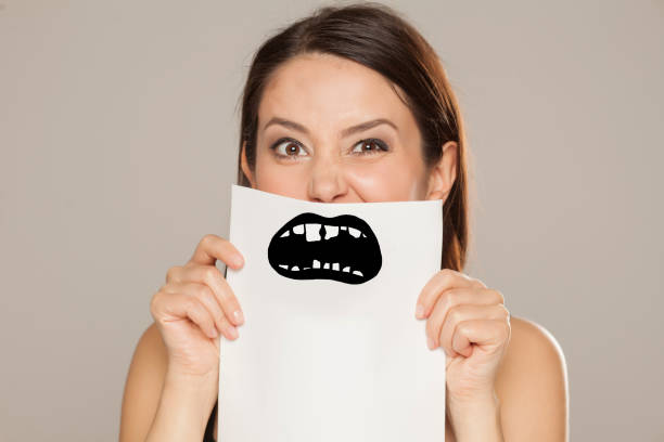 istock young woman with bad teeth drawn on paper on gray background 1086566984
