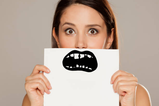 istock young woman with bad teeth drawn on paper on gray background 1086566986