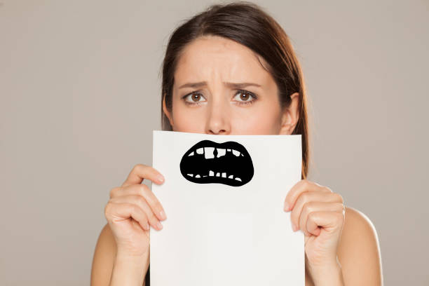 istock young woman with bad teeth drawn on paper on gray background 1086566990