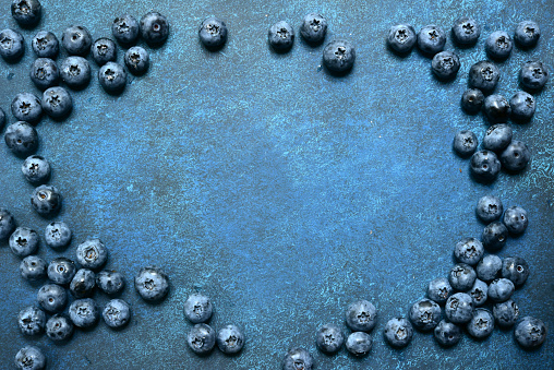 Food background with fresh blueberry on a dark blue slate, stone or concrete background.Top view with copy space.