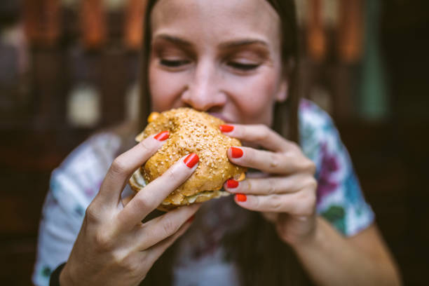 おいしいハンバーガーを楽しむ - tasting women eating expressing positivity ストックフォトと画像