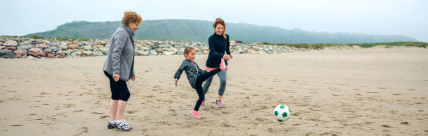 istock Three generations female playing soccer on the beach 1086585974