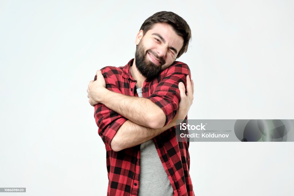 portrait confident smiling man hugging himself. I am the best concept. portrait confident smiling man hugging himself. I am the best concept. Soft clothes after washing Embracing Stock Photo