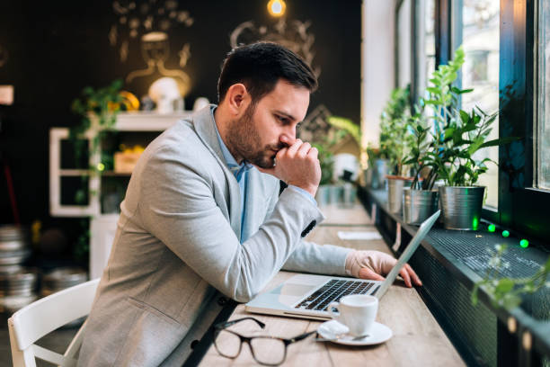 istock Serious young man with bandaged hand looking at laptop while sitting at the cafe. 1086602830