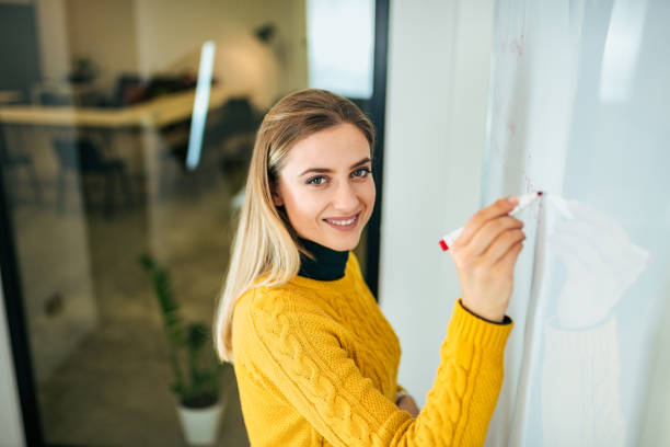 istock Casual young woman writting on whiteboard. 1086603150