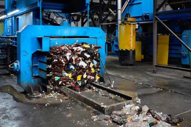 istock Modern waste sorting and recycling plant, hydraulic press makes wired bale from pressed PET bottles for processing and reuse of plastic 1086605136