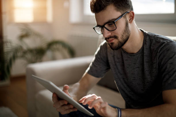 istock Young man using social media at home 1086607070