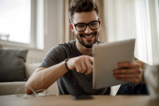 istock Smiling young man using social media at home 1086607916