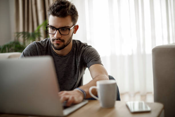 istock Teenage boy using laptop at home 1086608174