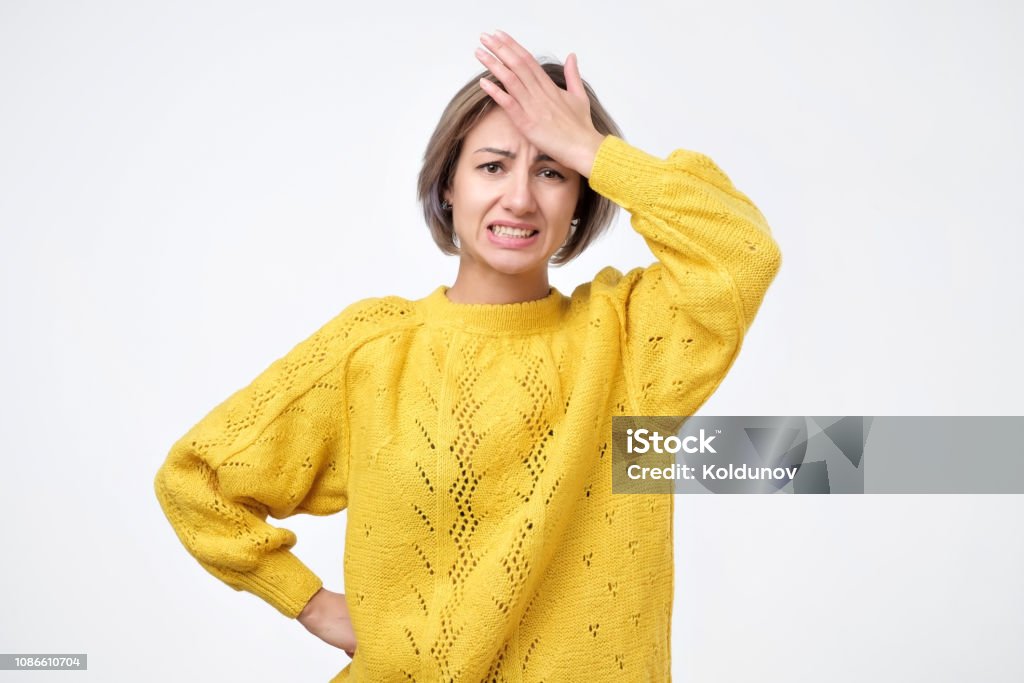 Retrato de jovem animado no suéter amarelo segurando sua cabeça - Foto de stock de Lembrete royalty-free