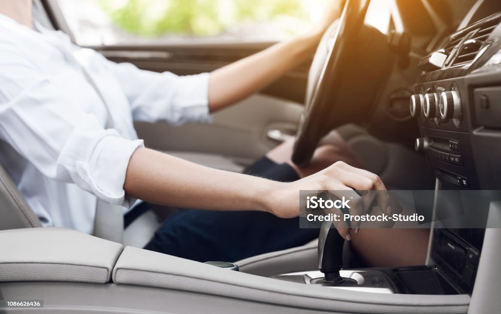 Business woman driver shifting automatic transmission and driving Business woman driving and shifting automatic transmission, side view Gearshift Stock Photo