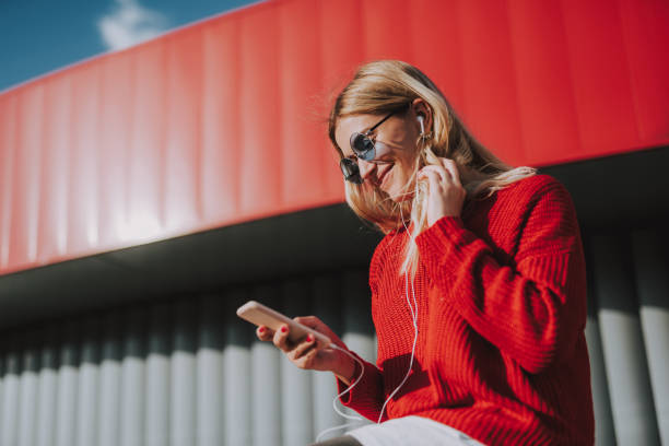 istock Charming young lady in glasses using cellphone outdoors 1086628568