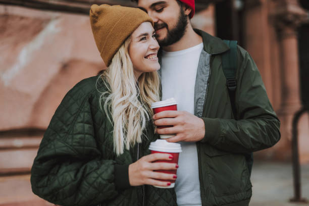 istock Loving young couple with hot drinks spending time outdoors 1086628600
