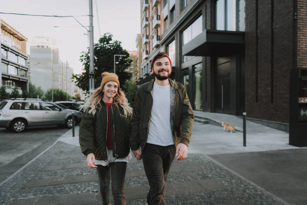 istock Beautiful young couple holding hands while walking on the street 1086632034